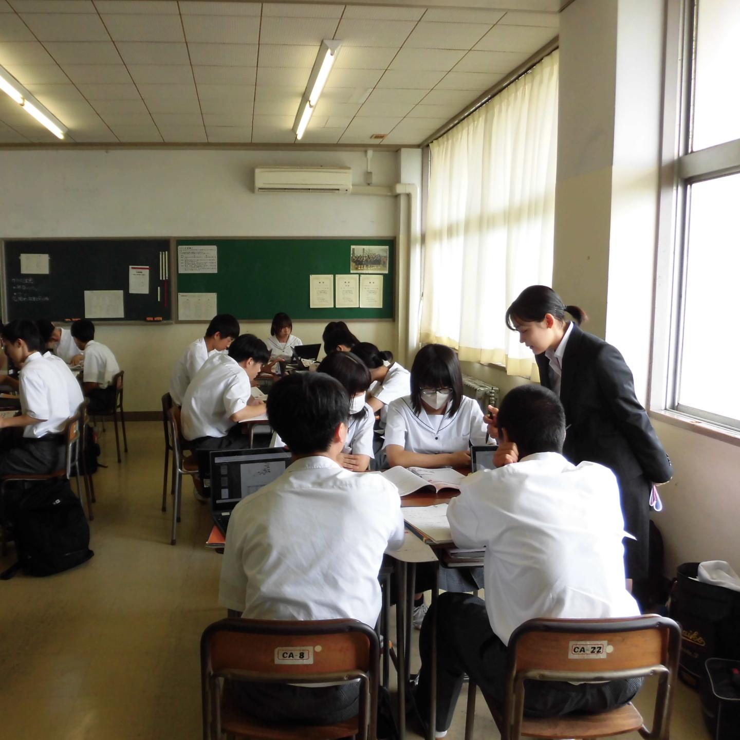 教室でグループに分かれて生徒が話しあっている