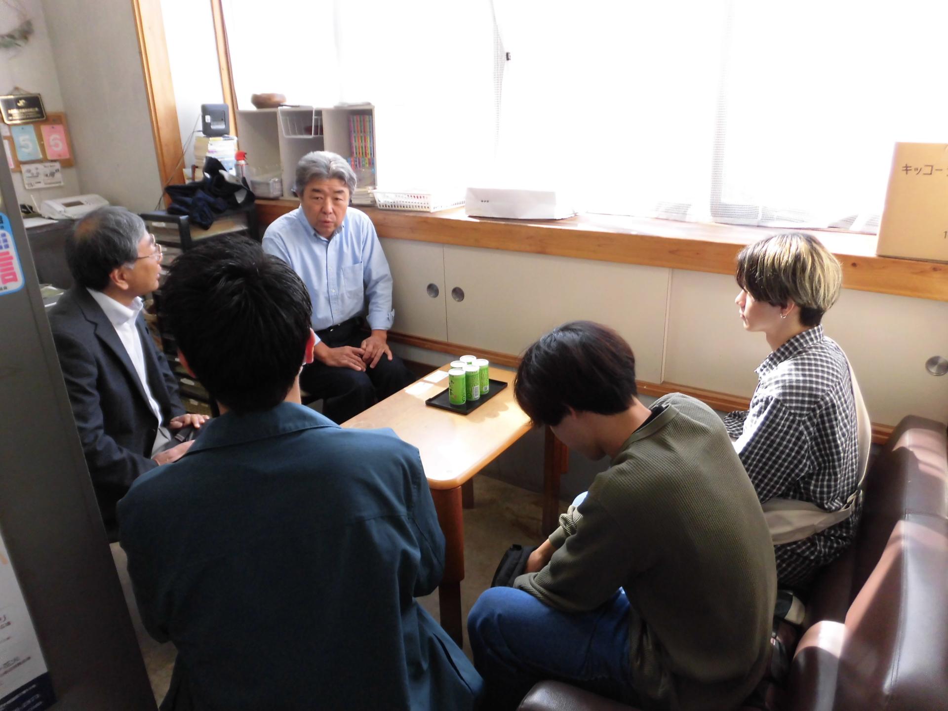 伊富味噌醤油店の担当者の説明をうける大学生