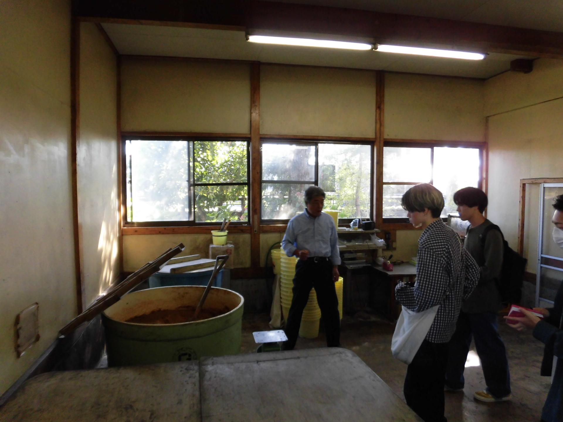伊富味噌醤油店の工場で樽内の熟成具合など実際に確認している