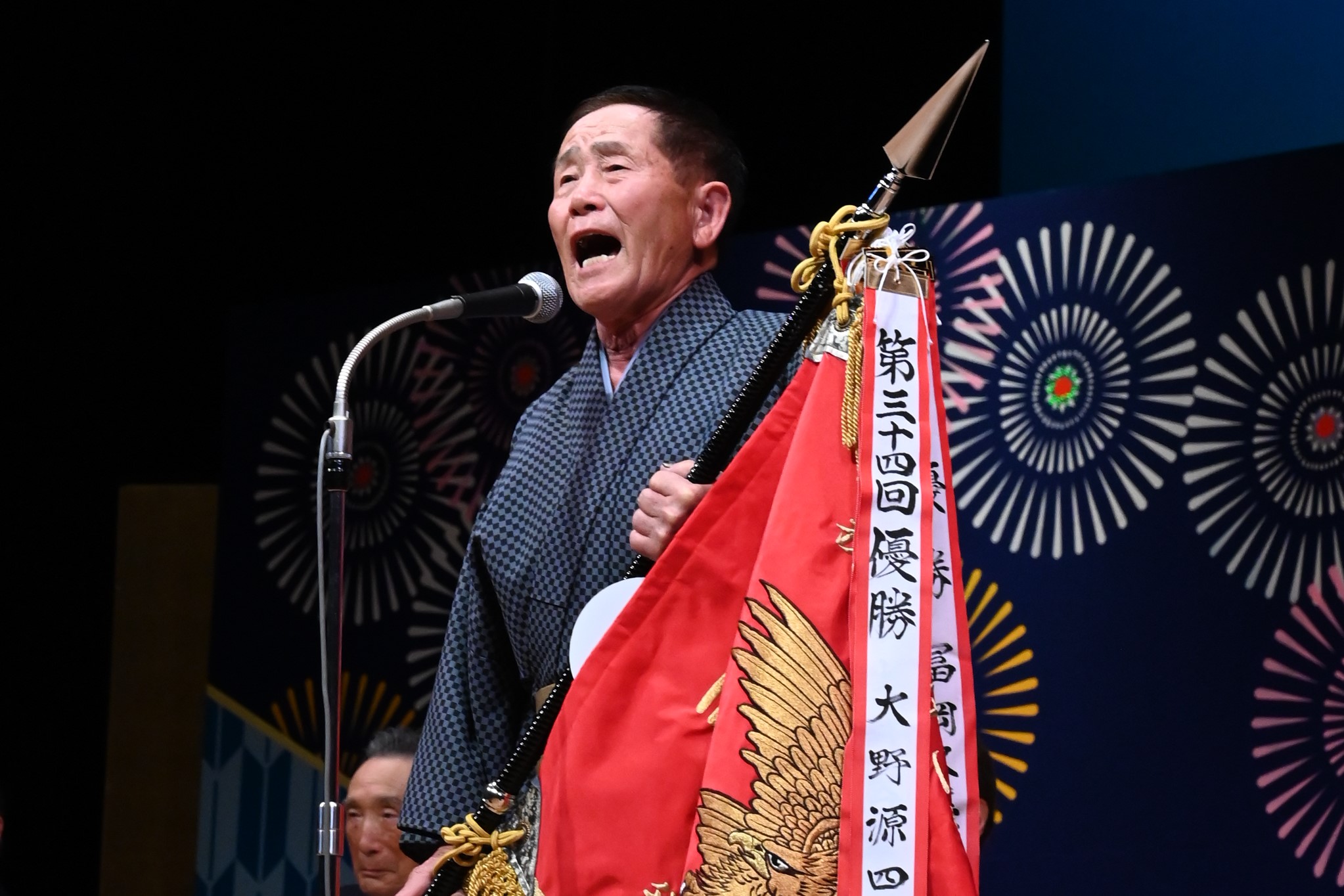優勝旗を持って唄う大野さん