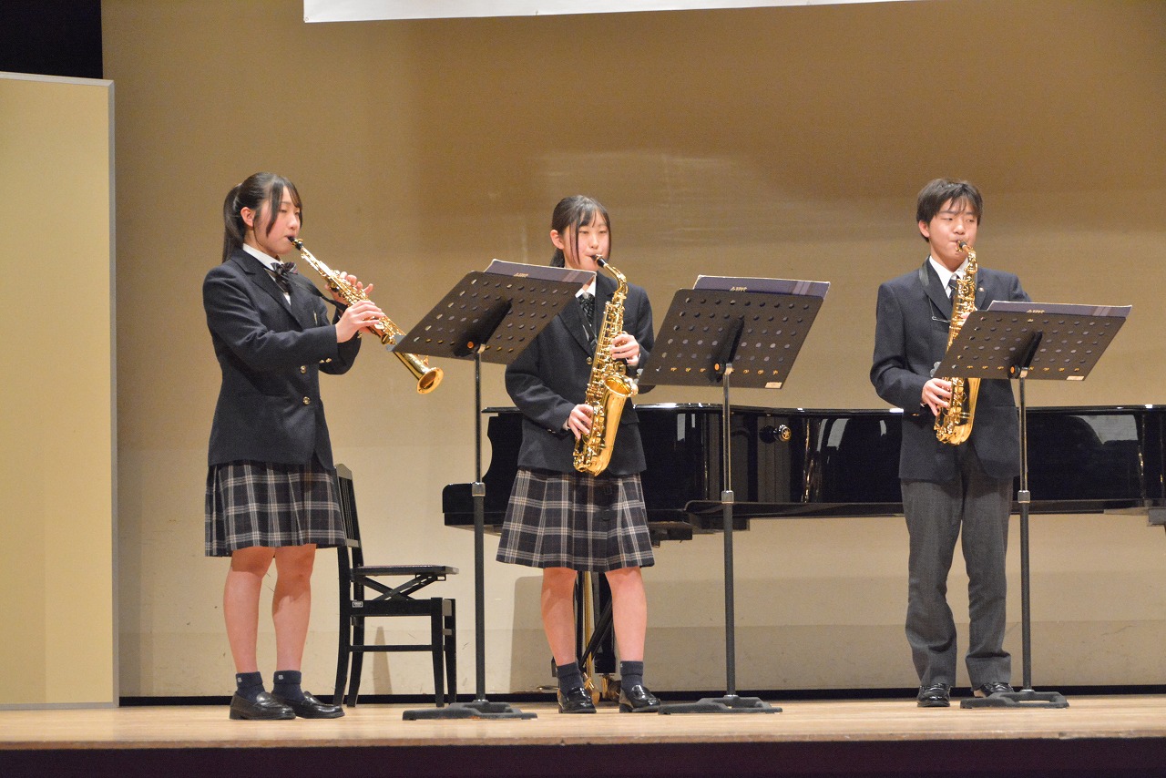 高校生3名がサックスを演奏している