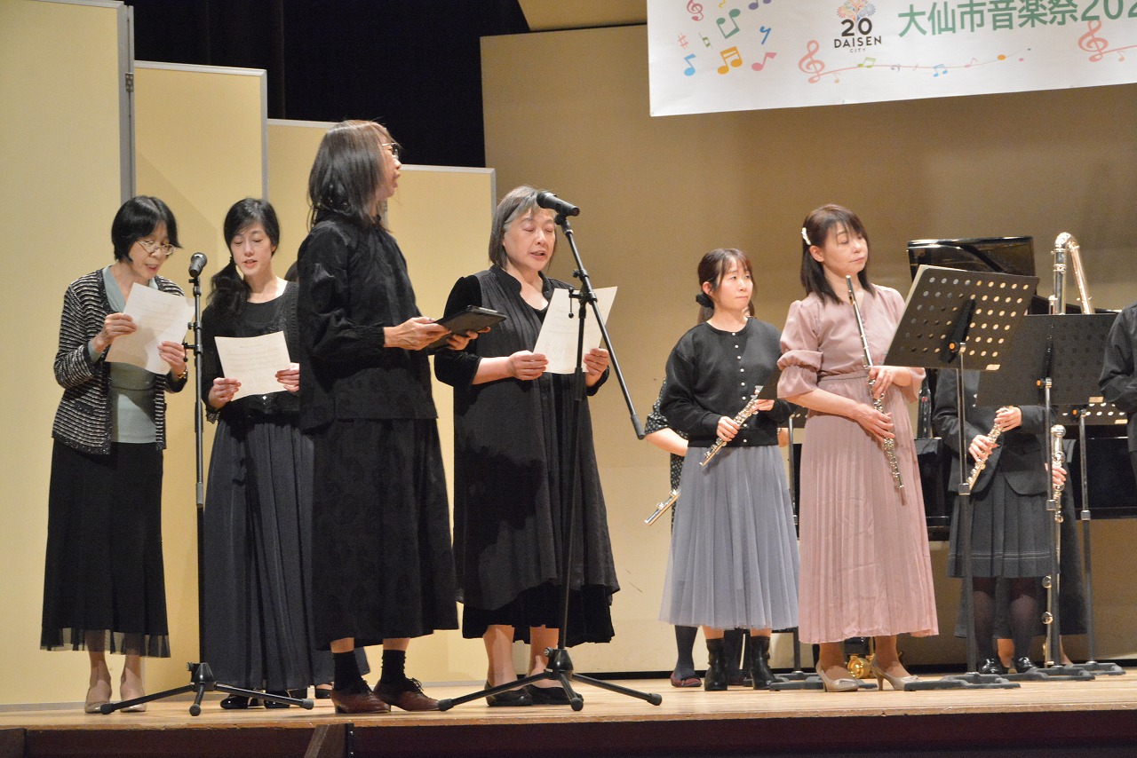 数名の女性がフルート演奏と合唱
