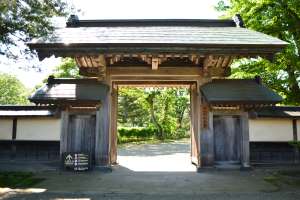 木々の木陰にたたずむ正門、タップするとよくあるお問い合わせのページに移動します