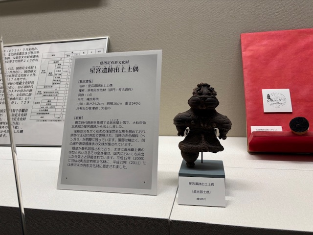 星宮遺跡出土土偶「遮光器土偶」と説明パネルの展示の様子