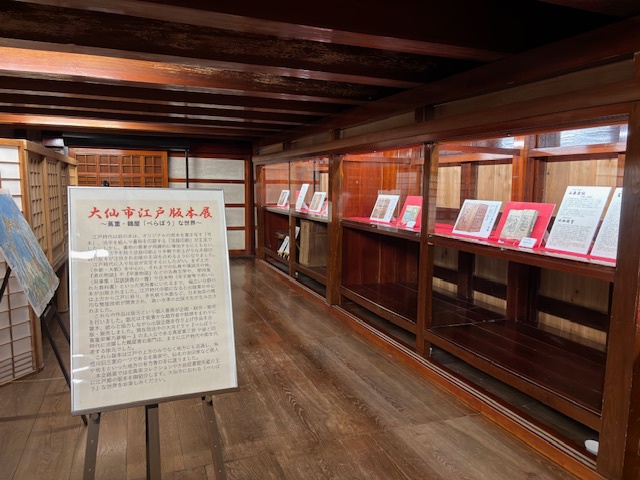 旧本郷家住宅文庫蔵に設置された展示品の様子、パネルでの解説、ケースに並べられた書籍など