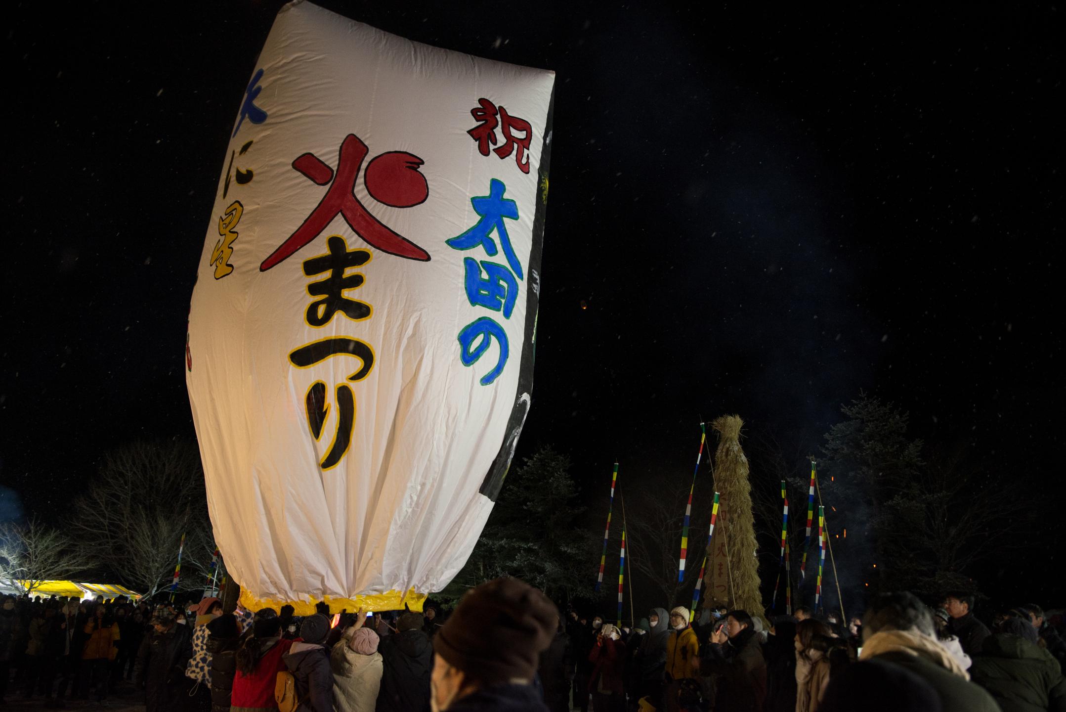 夜の闇に紙風船が飛び立つ写真