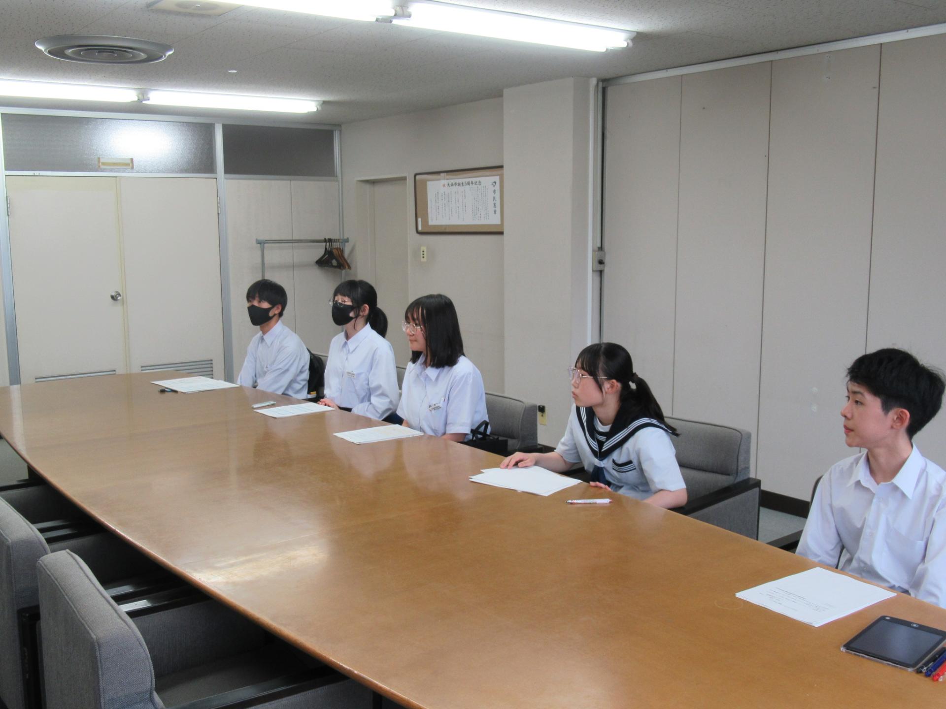 勉強会の様子（講師の説明を聞くレポーター3人）