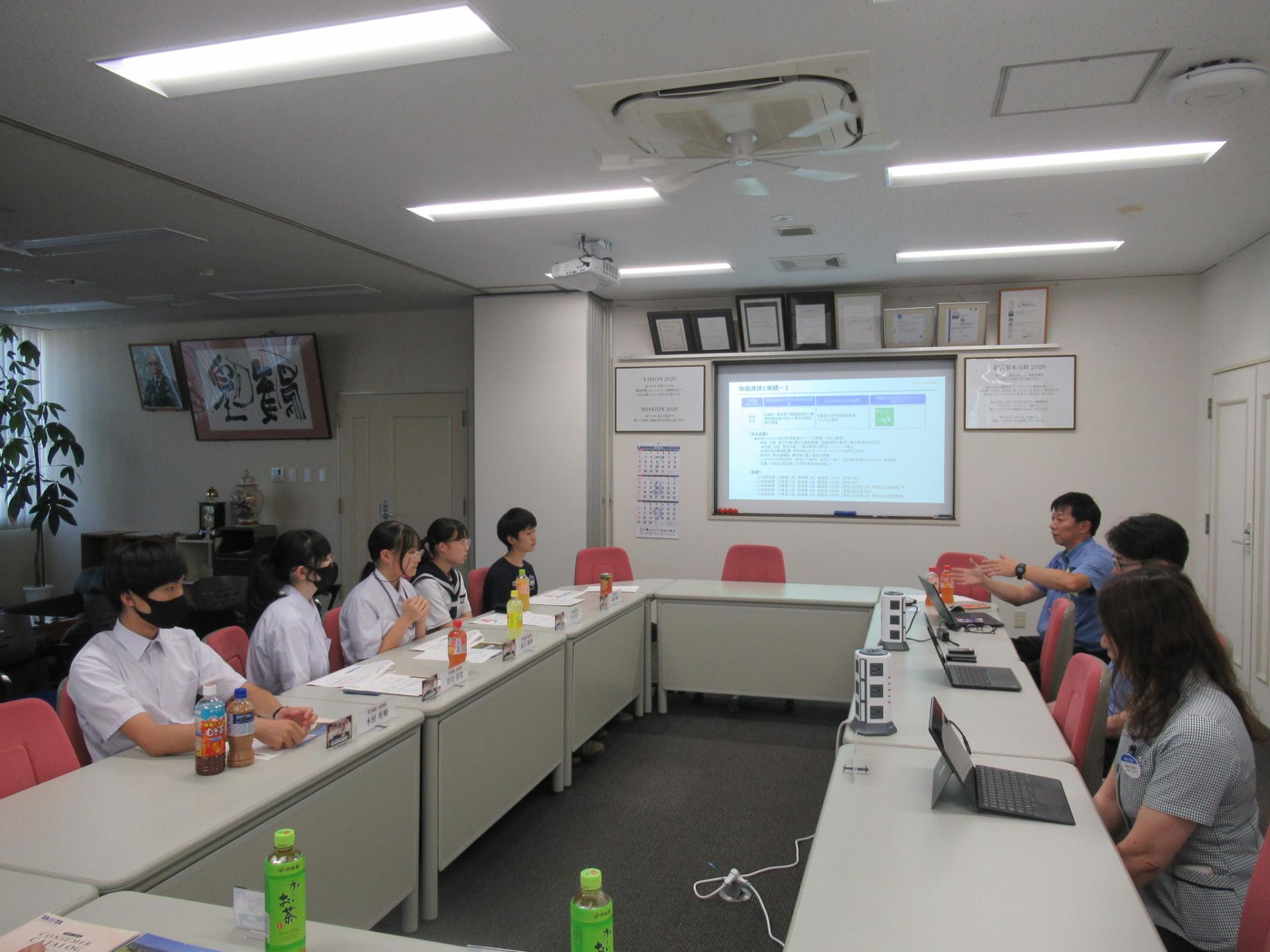 企業訪問（株式会社タニタ秋田）担当者と意見交換するサポーター