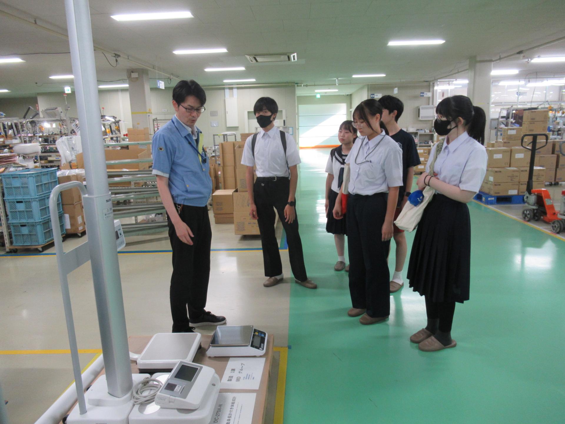 企業訪問（株式会社タニタ秋田）、会社内部の作業風景を見学するサポーター