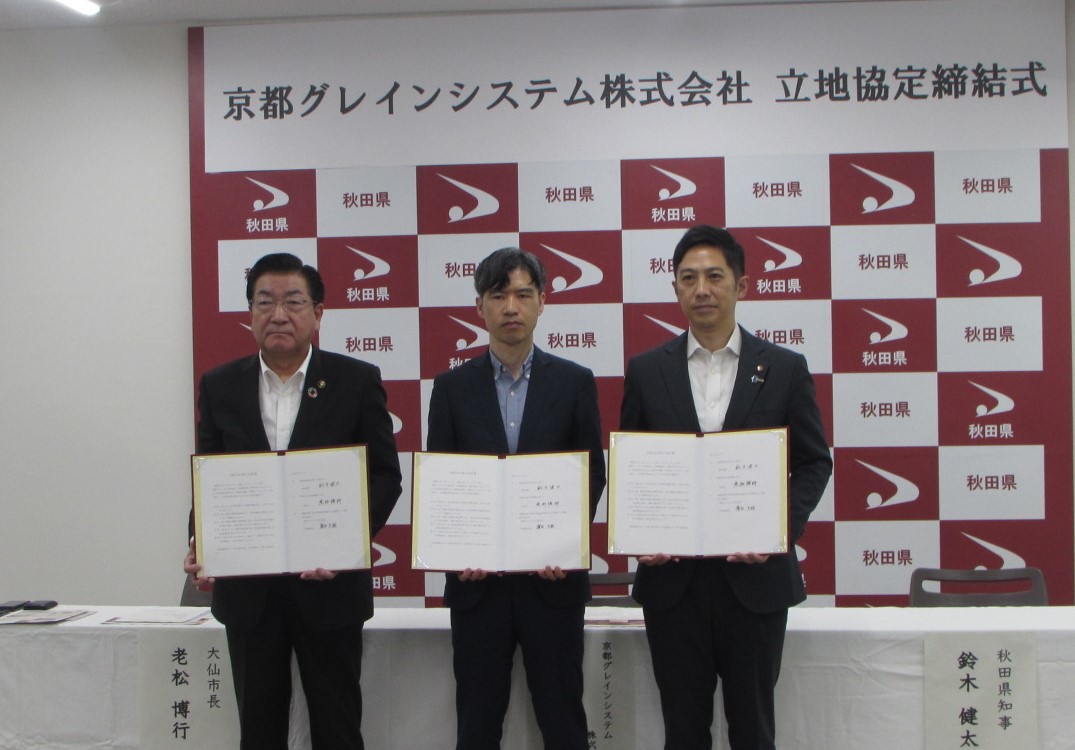 協定書を持つ3人の男性、続けて被写体を説明します