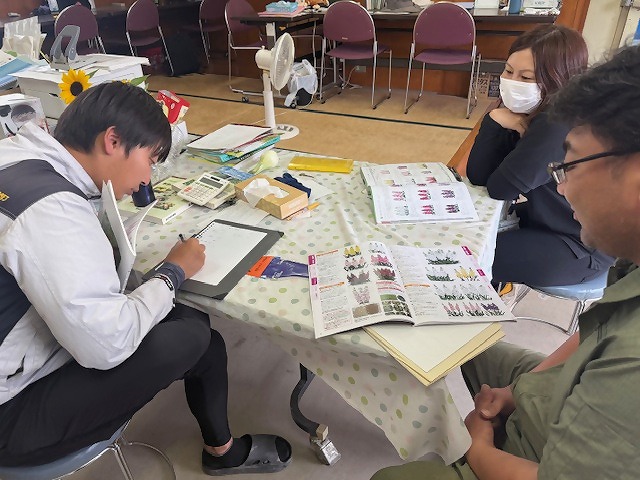 アドバイスを受けてメモを取る研修生