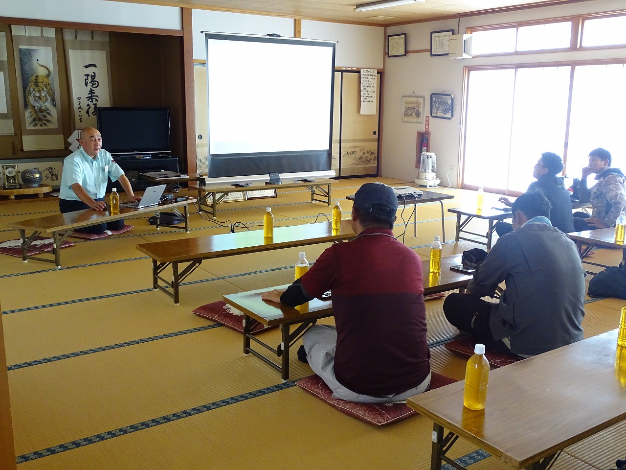 地元集落会館で、事故につながる操縦について講師の話を聞く研修生