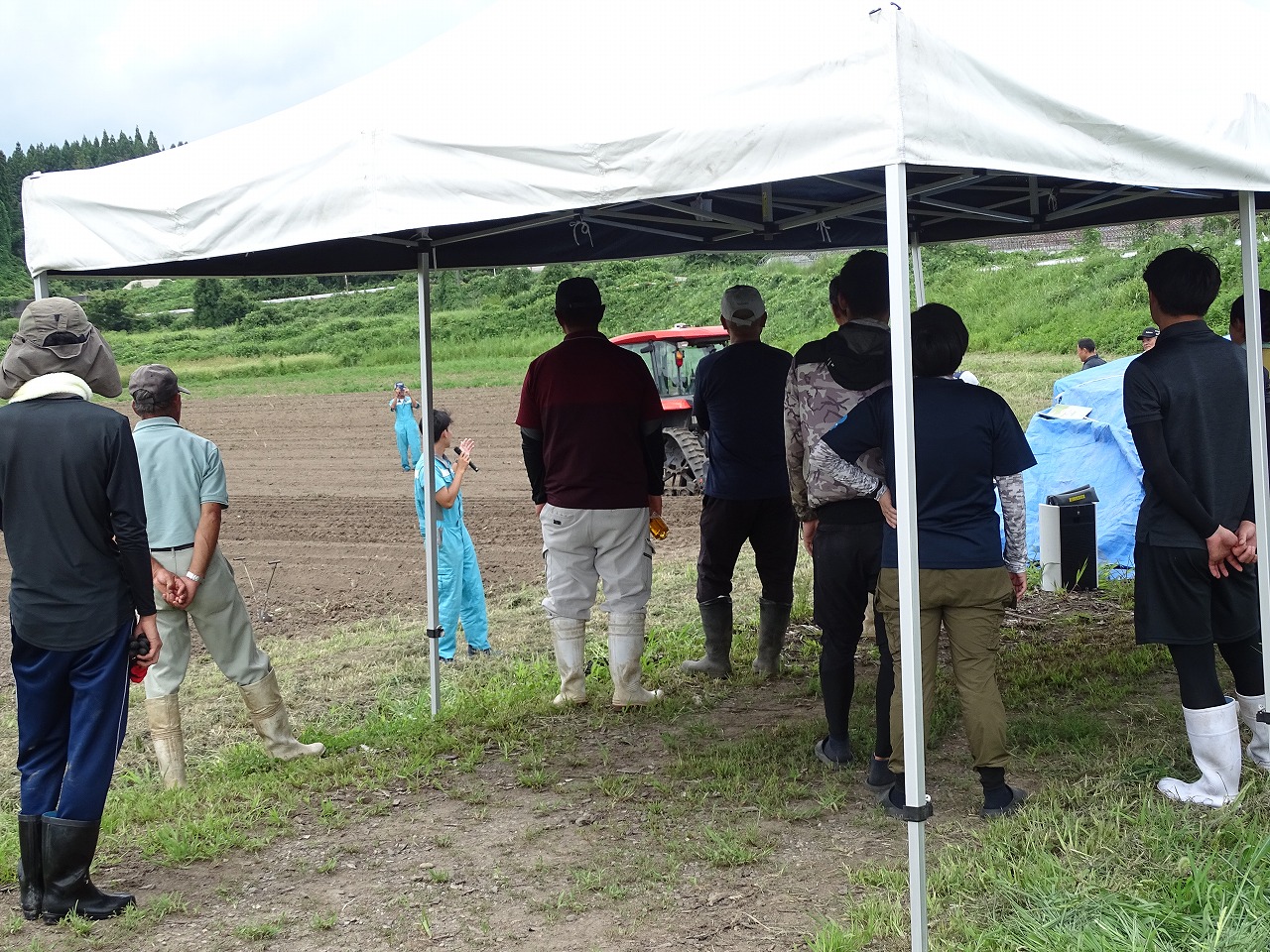 現場で株式会社秋田クボタの職員の説明を聞く参加者
