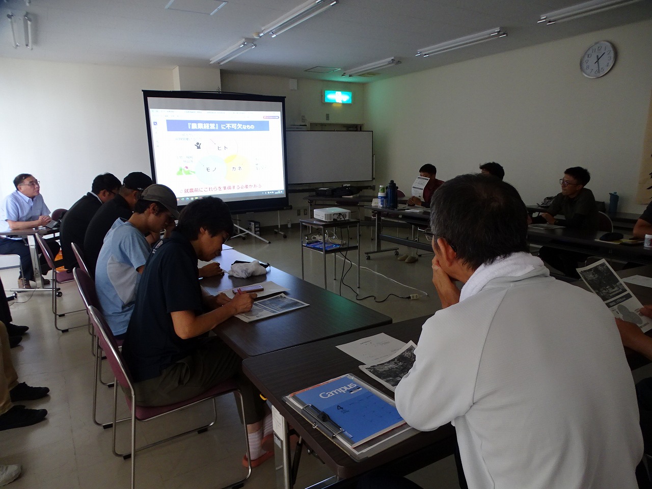 スライドを見ながら農業経営に不可欠なものについて学ぶ研修生