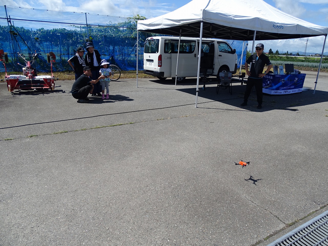 秋田クボタブースでドローンのおもちゃを操縦する研修生
