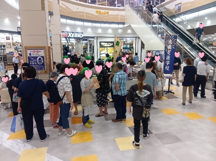 マルシェ（販売）の様子、子どもから大人までたくさん方が出品物を見ている