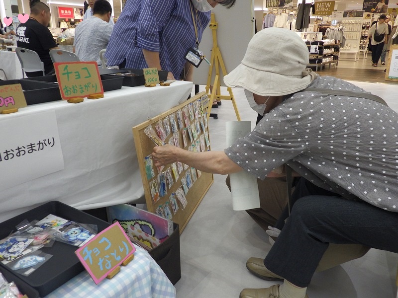 チョコおおまがり販売ブース、お客さんが商品を手に取り品定めしている