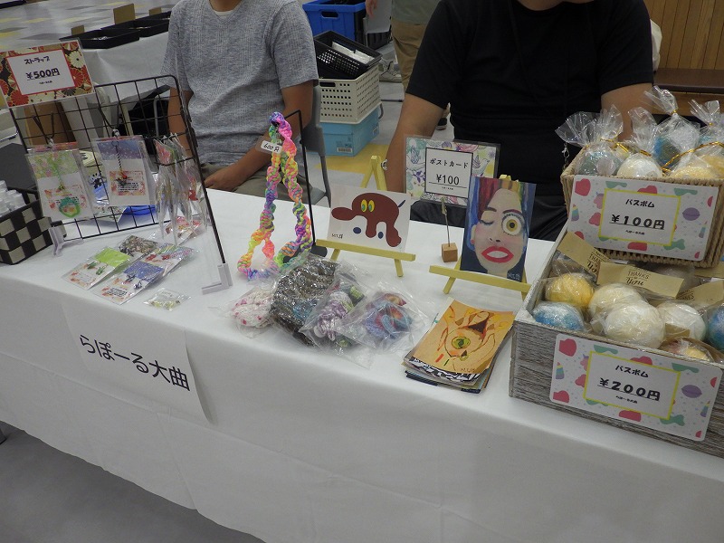 らぽーる大曲の販売ブース、ビーズアクセサリー、ハンドメイドポーチ、ポストカード、バスボムなどが並んでいる