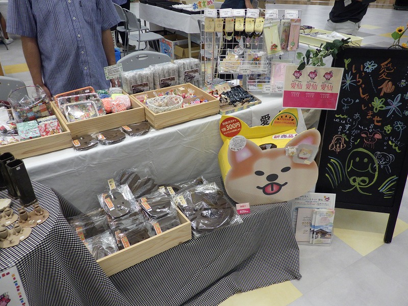 愛仙(あいせん)の販売ブース、木工製品、和紙工芸などが並んでいる