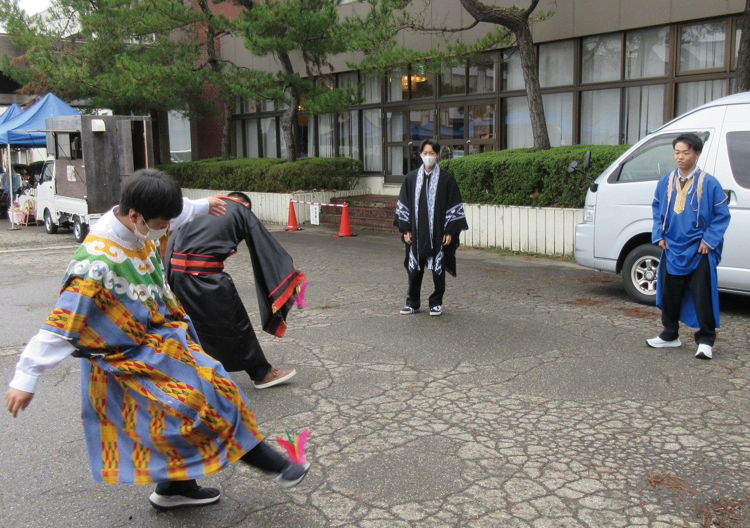 過去の開催の様子、屋外で民族衣装を着る体験をして踊る若人