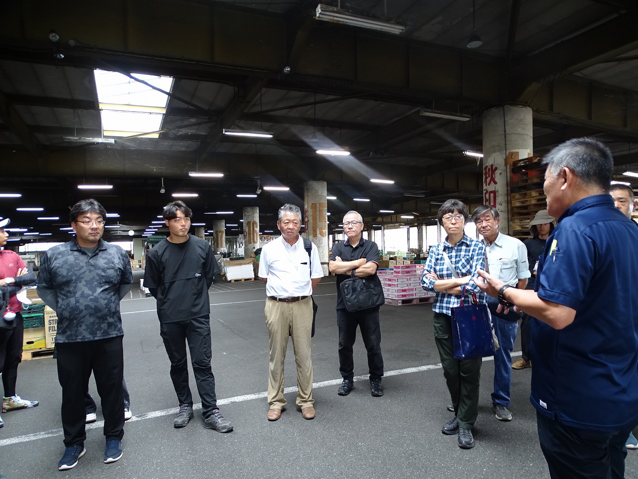 市場の設備について話を聞く研修生