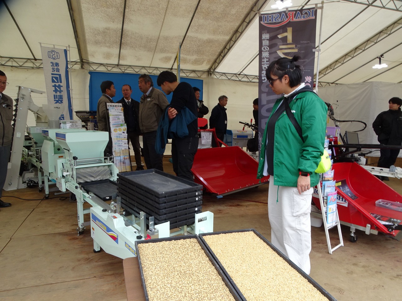 水稲の播種をする機械を見学する研修生