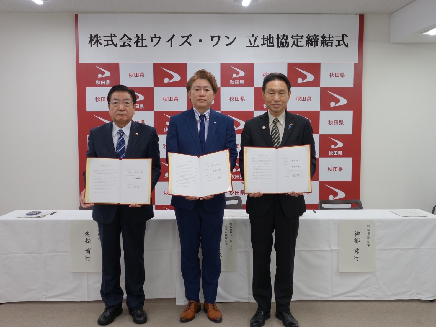 立地協定締結式、3者による記念撮影、続けて被写体の配置と名前を説明します