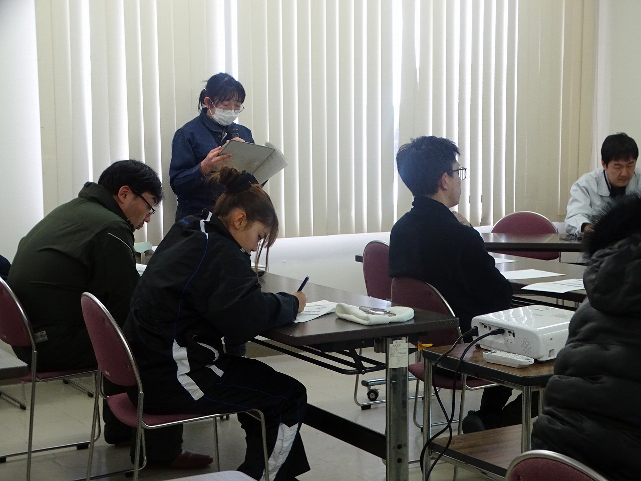 公私の説明のメモを取る研修生