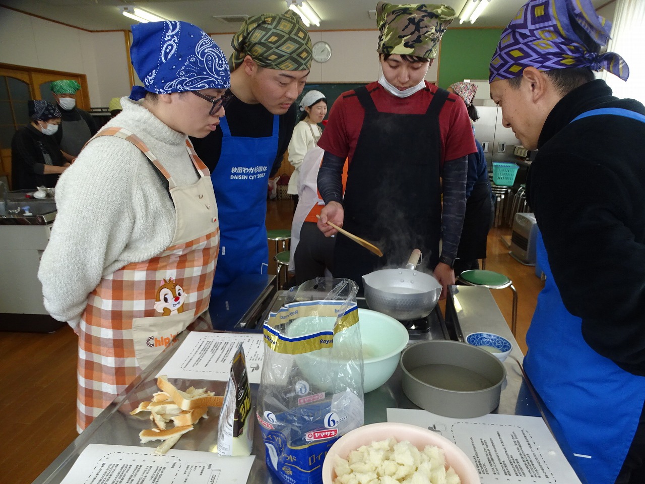 寒天を焦げないように煮詰める研修生、格好は三角巾・マスク・エプロン