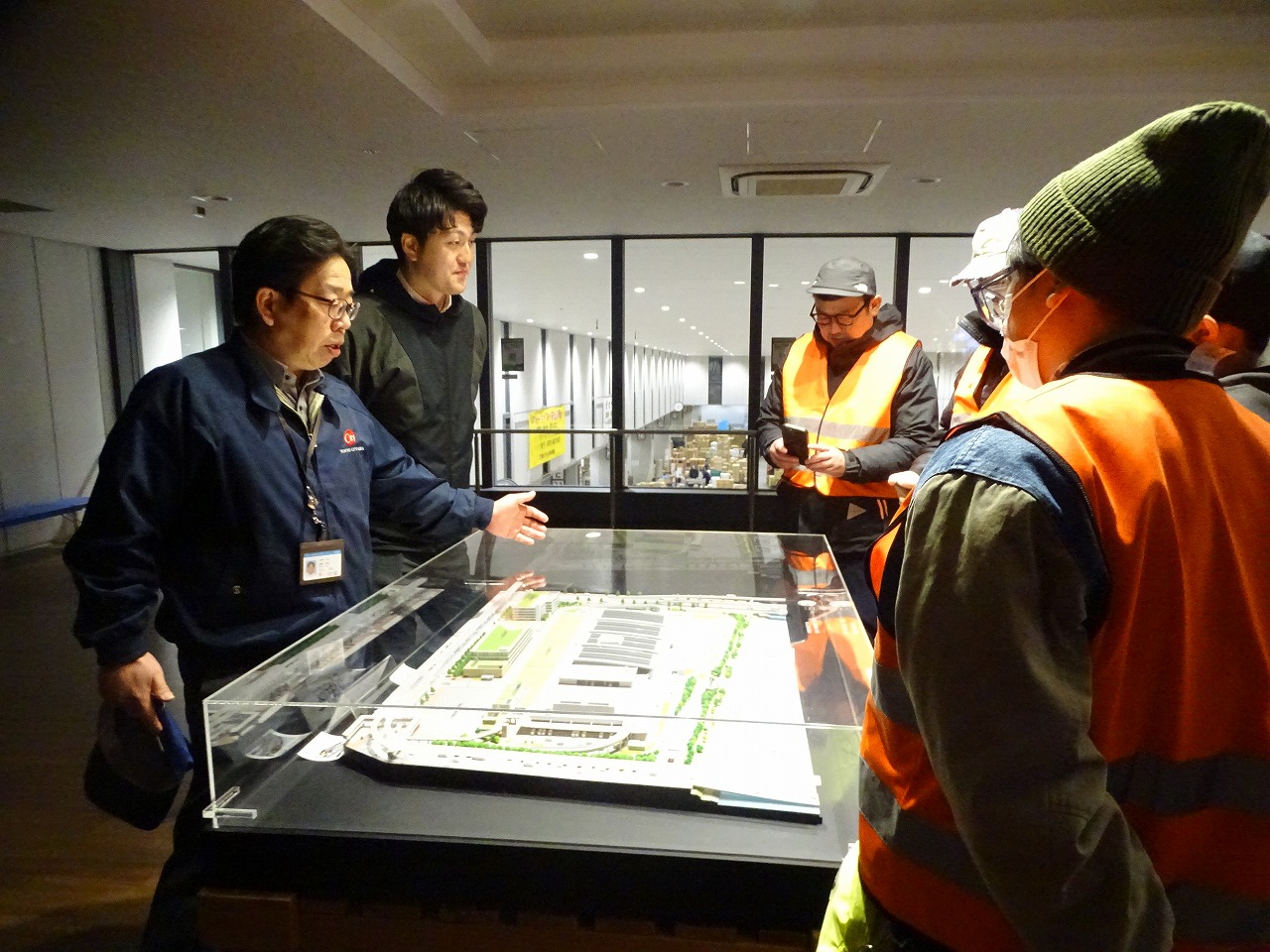 豊洲市場青果棟の模型を見ながら物流について説明する担当職員