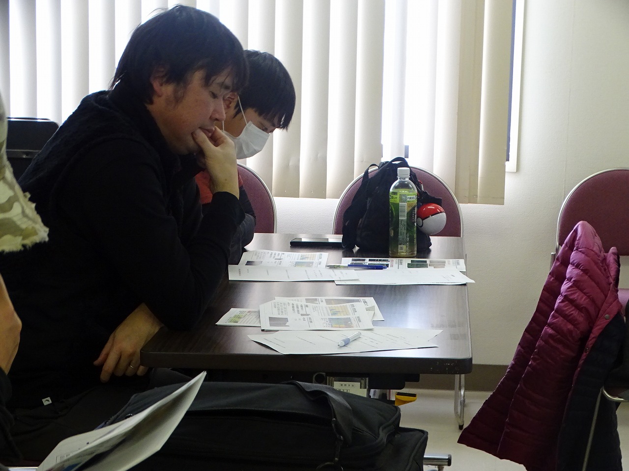 花きの資料を熱心に読む研修生と研修修了生