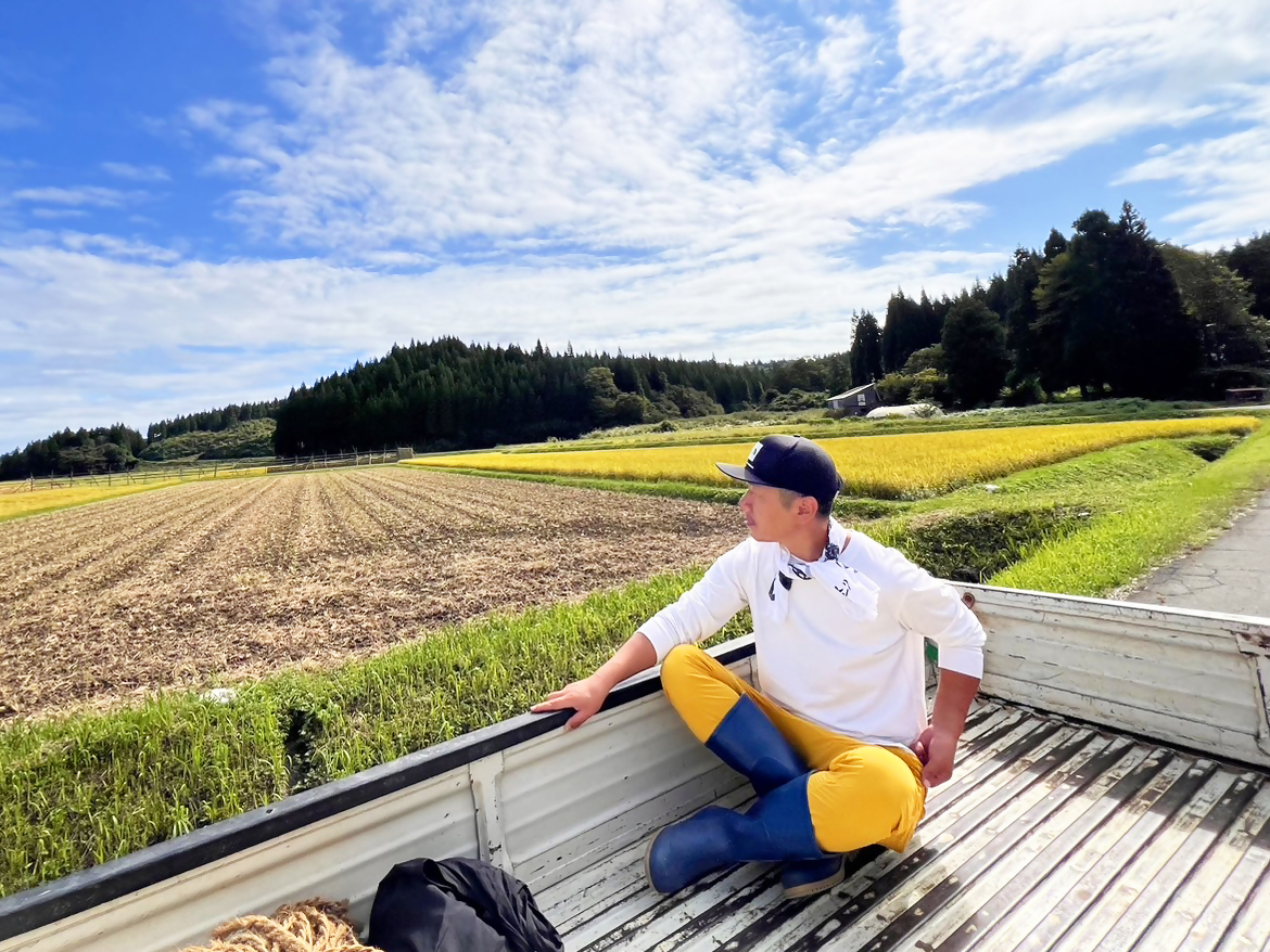 停車している軽トラの荷台で風を感じる男性隊員