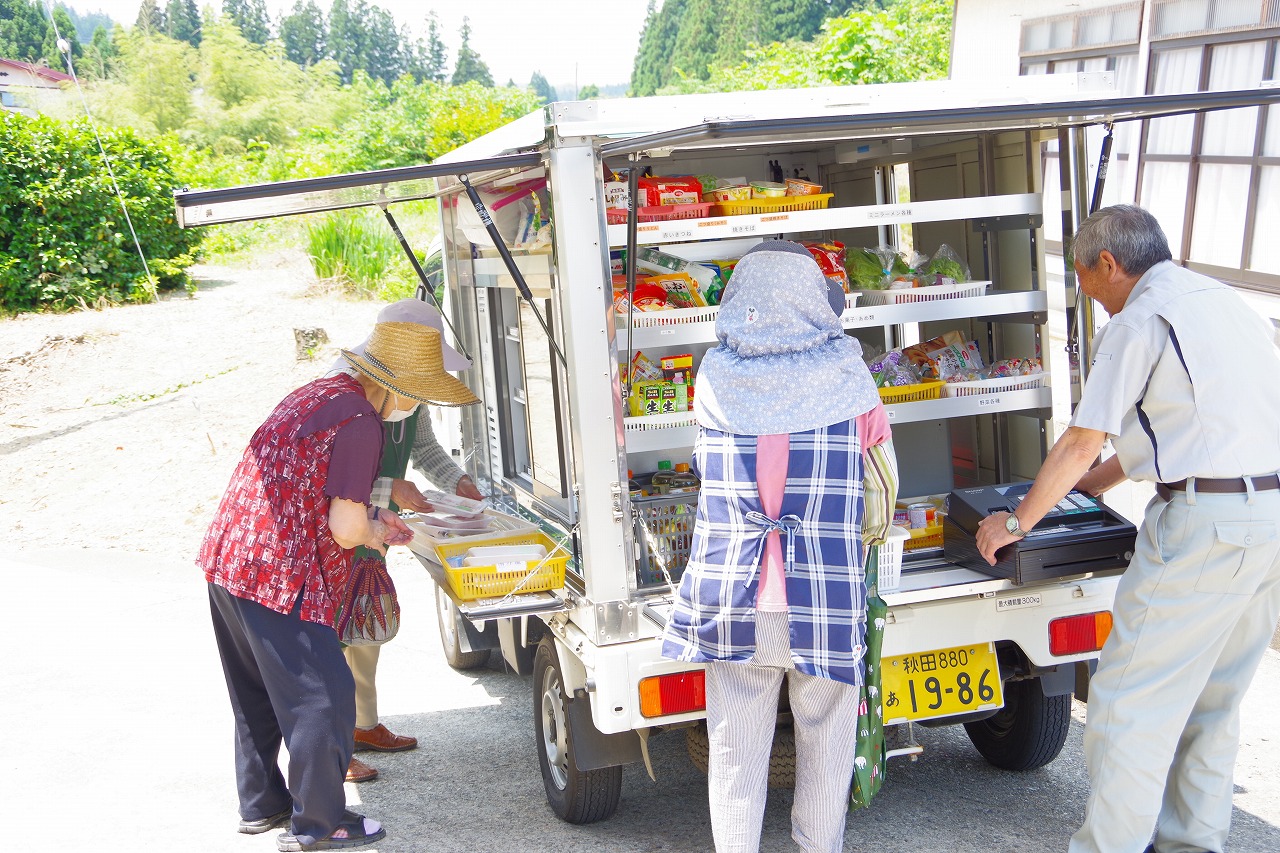 たくさんの商品をつんだ販売車に集まる地元住民