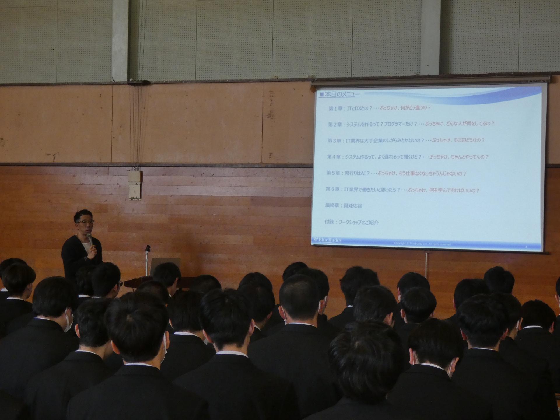 大曲工業高校でのセミナーの様子、講師がスクリーンを見ながら説明