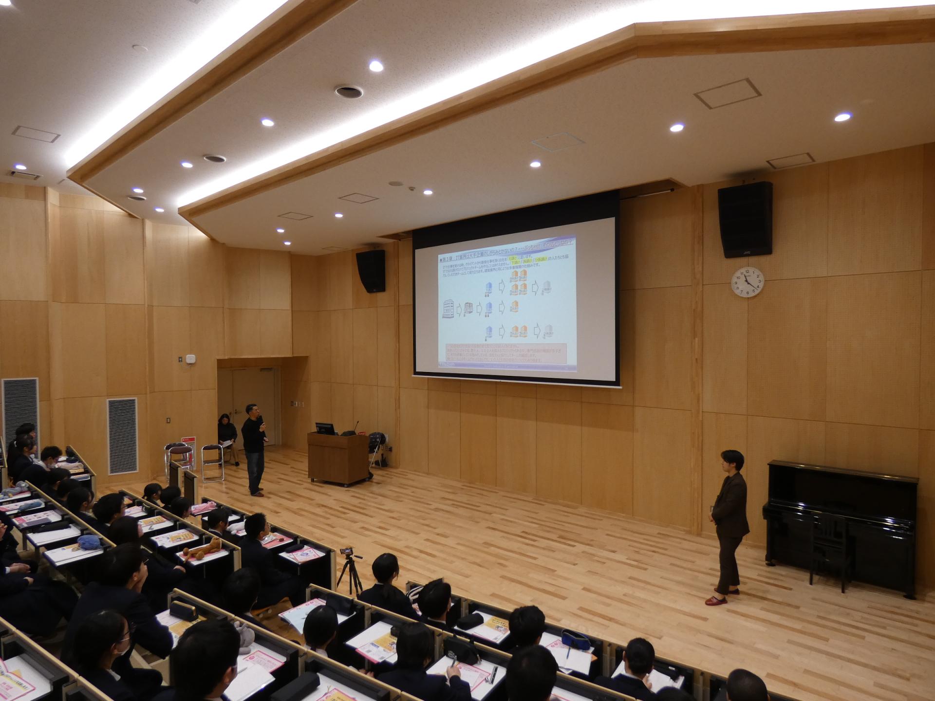 大曲高校でのセミナーの様子、講師がスクリーンを見ながら説明
