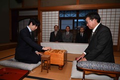 画像:藤井聡太竜王が、奥の間で職員の男性と碁盤の前に対面して座っている様子
