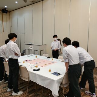 グループに分かれてグループワークをしている生徒たち、机のうえに模造紙を広げて話し合いの内容をまとめている