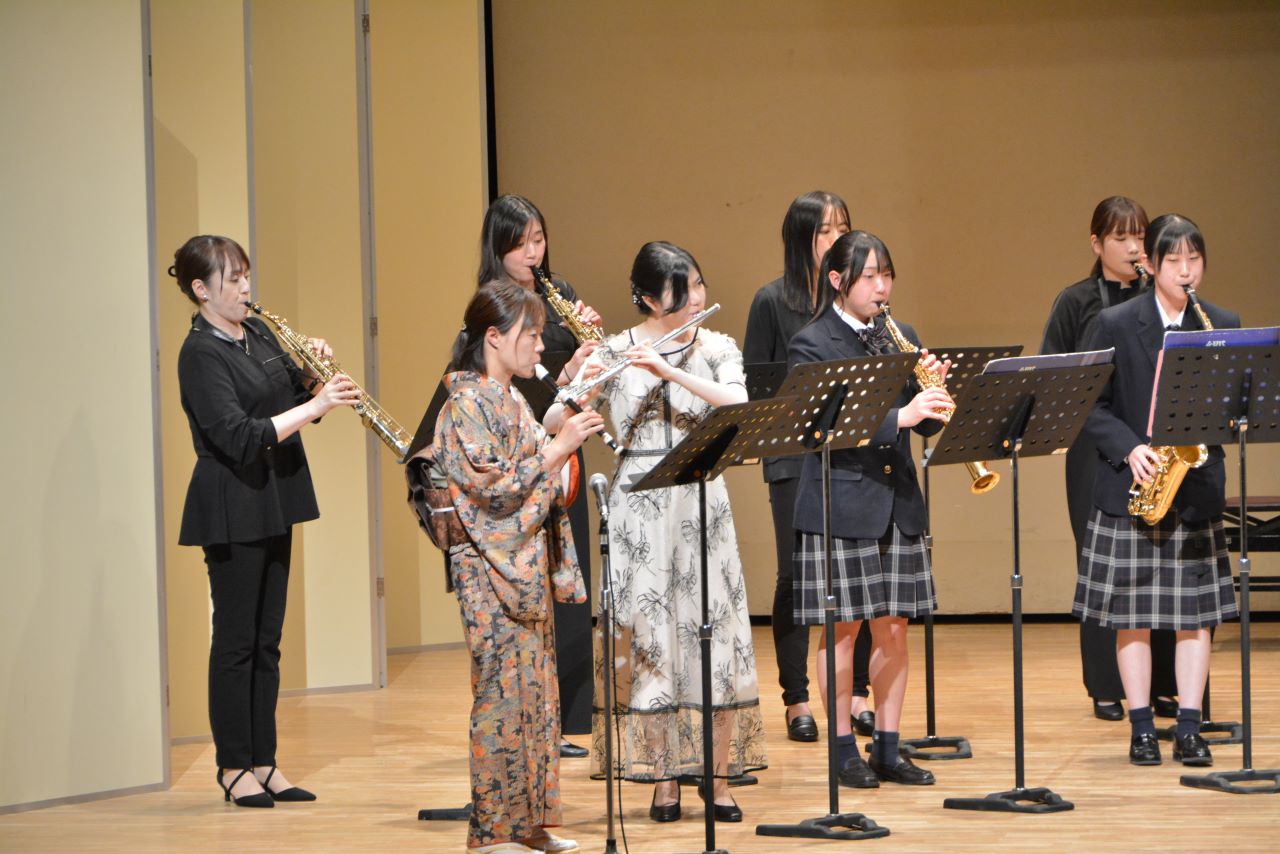 数名の女性が管楽器を演奏している