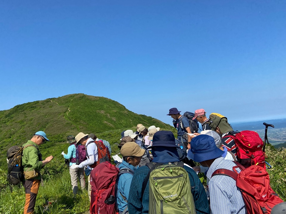 実技（登山）の様子、青い空と緑のコントラストを楽しむ受講生