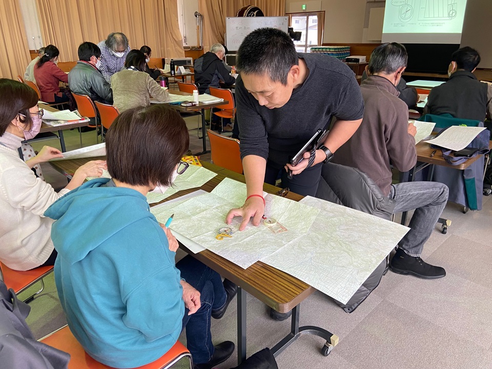 座学の様子、受講生が講師から指導を受けている