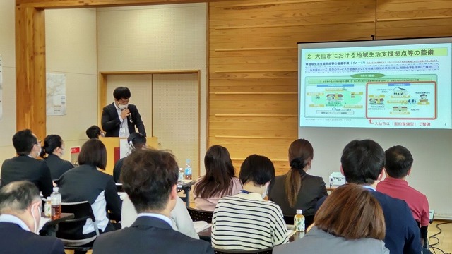 プロジェクターにスライドが映し出され、講演が行われている様子