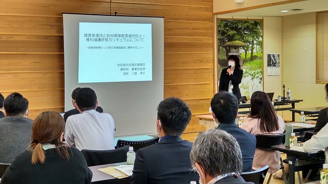 プロジェクターにスライドが映し出され、講演が行われている様子