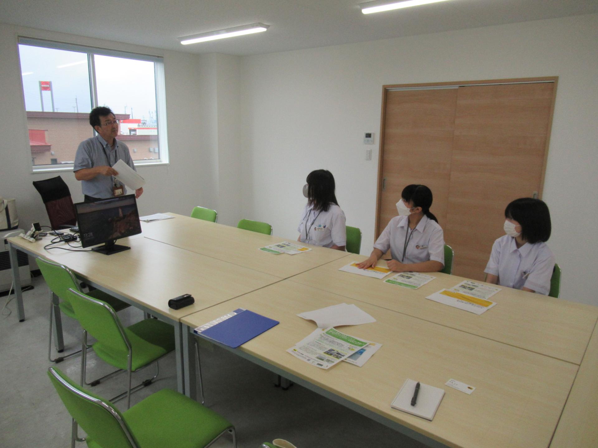 ヤマト運輸での勉強会の様子（担当者の説明を聞くレポーター3人）