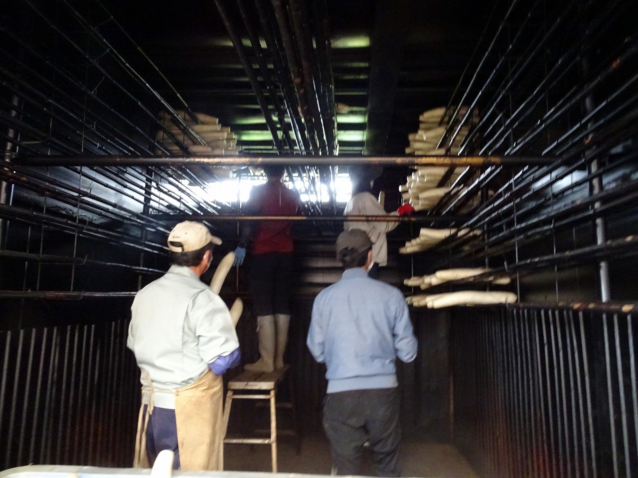 いぶし小屋の棚にダイコンを並べている様子
