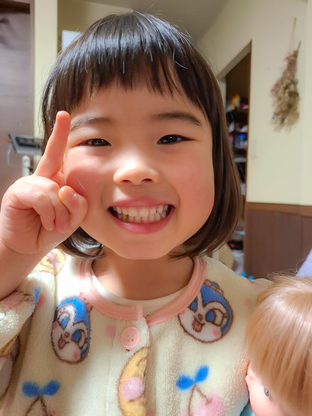 ピースサインしている笑顔の女の子の写真