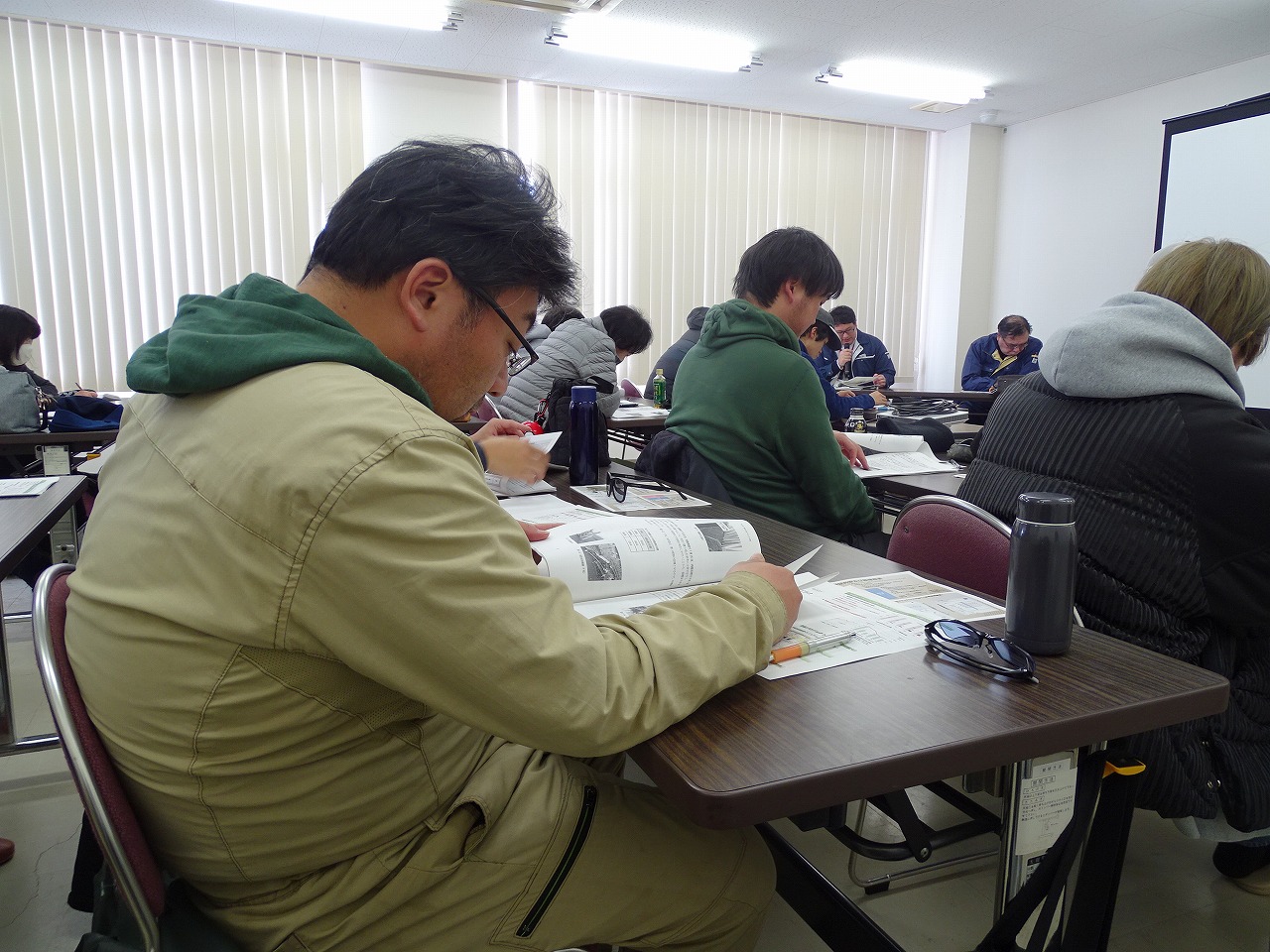真剣にメモをとる研修生