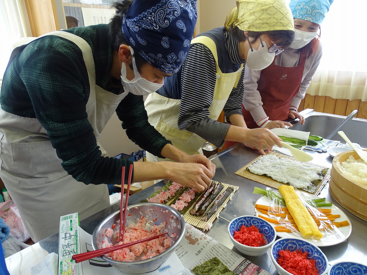 指導をうけながら太巻き寿司を作っている研修生