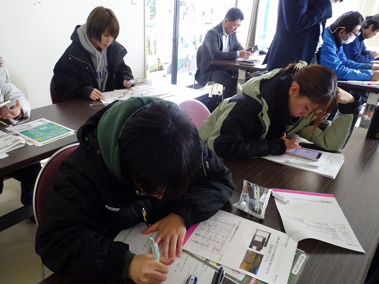 講師の説明のメモをとる研修生