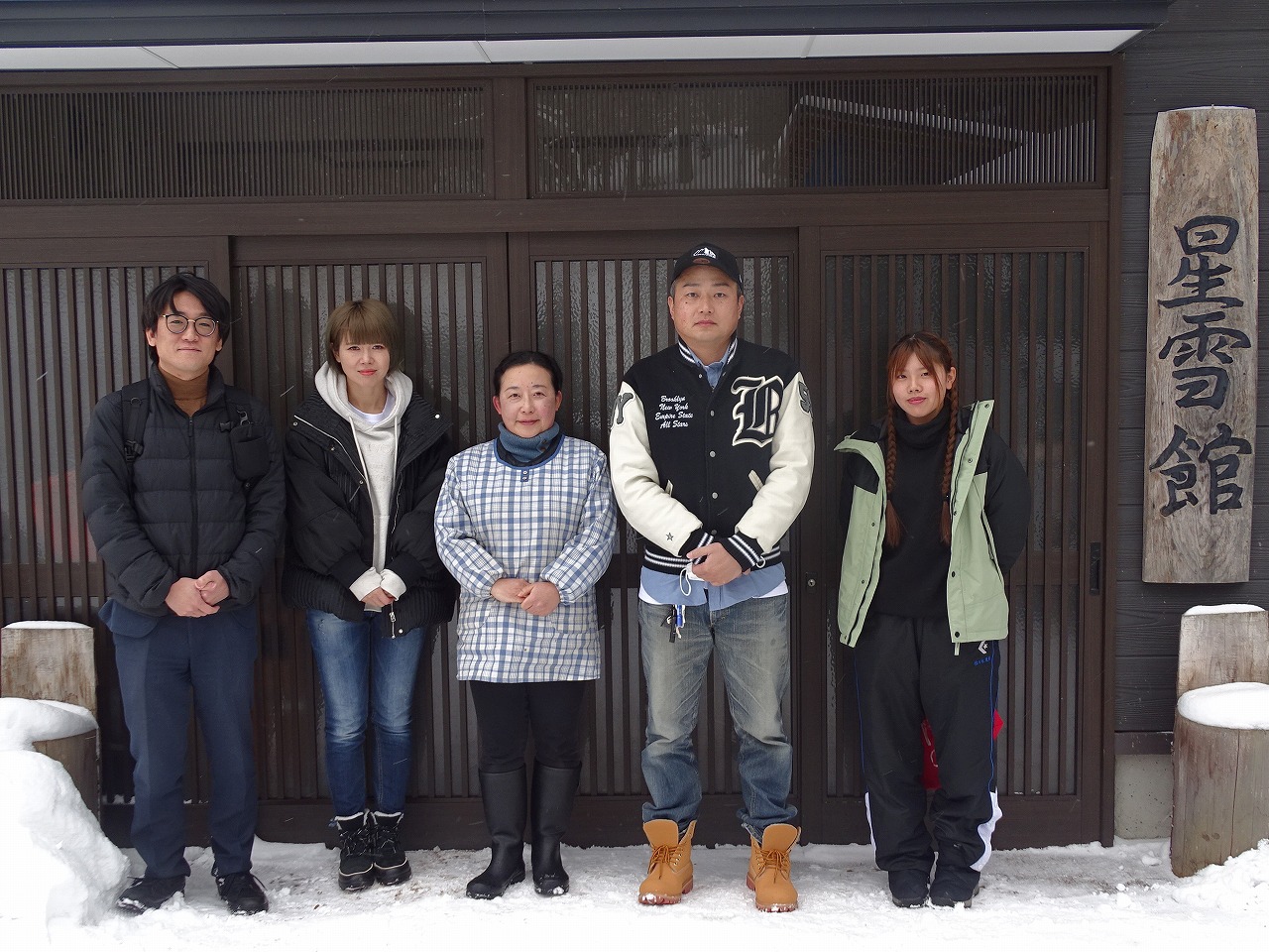星雪館の入り口にて記念写真(研修生4名と星雪館の代表)