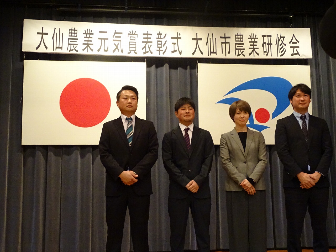 研修生がステージ上で記念撮影をしている様子